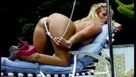 Naughty blonde sticks plastic tube up her ass from behind and loves